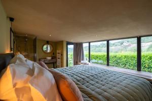 a bedroom with a large bed with a large window at La Villa Ava in Somme-Leuze