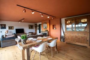 a living room with a table and a couch at La Villa Ava in Somme-Leuze