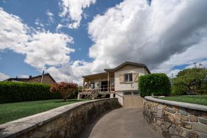 een huis met een stenen muur en een oprit bij La Villa Ava in Somme-Leuze