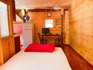 a room with a bed with a desk and a refrigerator at Le sorgenti - Chalet 12 in Palazzuolo sul Senio