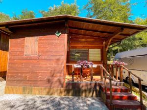 a wooden cabin with a porch with a table and a rv at Le sorgenti - Chalet 12 in Palazzuolo sul Senio