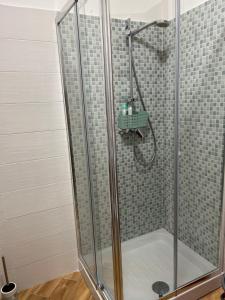 una doccia con cabina in vetro in bagno di La Dimora del Coach a L'Aquila