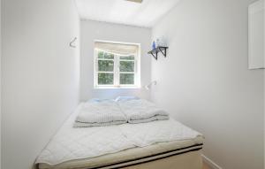 Ce lit se trouve dans un dortoir blanc doté d'une fenêtre. dans l'établissement Beautiful Home In Grevinge With Kitchen, à Grevinge