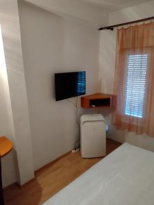 1 dormitorio con 1 cama y TV de pantalla plana en Family Majčica - villa Malo Misto, en Klek
