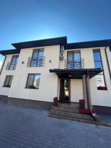 a large white house with stairs and windows at Holiday house in Vinnytsya
