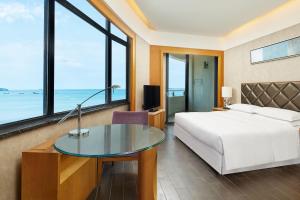 a bedroom with a bed and a desk and a bed and a bed at Four Points by Sheraton Hainan, Sanya in Sanya