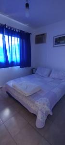 a large bed in a bedroom with a blue window at Las Colinas in Salta