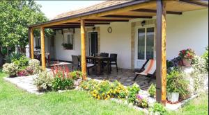 a covered patio with a table and some flowers at Pensions Airport in Podgorica