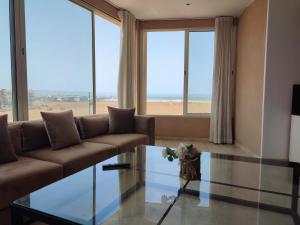 een woonkamer met een bank en een glazen tafel bij roof top duplex with solarium in Bouznika