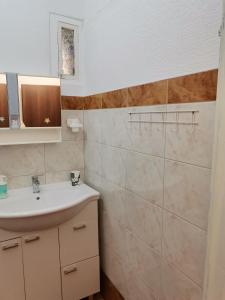 ein Bad mit einem Waschbecken und einem Spiegel in der Unterkunft Isabele in Brodarica
