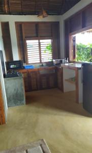 a kitchen with wooden cabinets and a counter top at Hotel Océan Beach Sakatia in Nosy Be