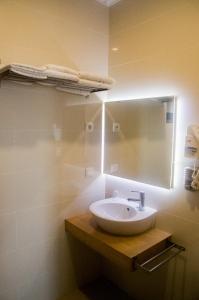 La salle de bains est pourvue d'un lavabo et d'un miroir. dans l'établissement Make it Happen Farm, à Urzelina