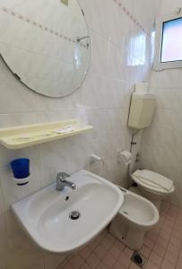 La salle de bains blanche est pourvue d'un lavabo et de toilettes. dans l'établissement HOTEL BLUE SKY, à Rimini
