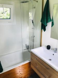 a bathroom with a white sink and a shower at TinyHouse & Garden in Geceľ