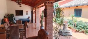 eine Terrasse mit Stühlen, einem Tisch und einem Gebäude in der Unterkunft CortijoRamon in El Brosquil