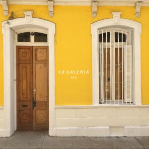 un edificio amarillo con puerta y ventana en La Galería B&B en Valparaíso