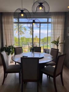 a dining room with a table and chairs and a large window at D ARC Leisure Home By The Sea in Panglao