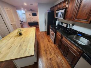 eine Küche mit einer Holzoberfläche und einem Holztisch in der Unterkunft Luxury 2 bed apt, mins to NYC! in Union City