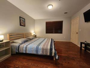 ein Schlafzimmer mit einem Bett mit einer gestreiften Decke und einem Fenster in der Unterkunft Luxury 2 bed apt, mins to NYC! in Union City