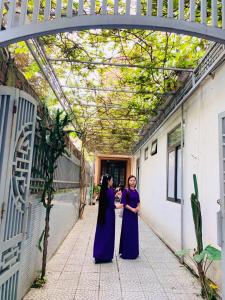 two women are standing under an archway at Ngọc Bích Home Huế in Hue