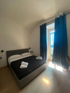 1 dormitorio con 1 cama con cortinas azules y ventana en Maison Dante, en Nápoles