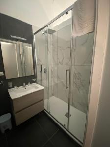 a bathroom with a glass shower and a sink at Maison Dante in Naples