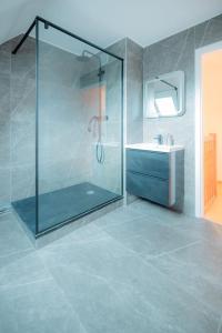 ein Bad mit einer Glasdusche und einem Waschbecken in der Unterkunft Coeur De Ville Colmar in Colmar