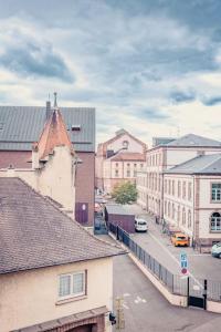 Blick auf eine Stadtstraße mit Gebäuden und Autos in der Unterkunft Coeur De Ville Colmar in Colmar