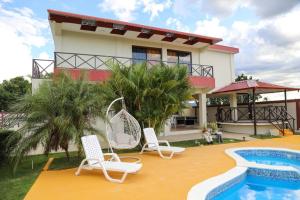 una casa con 2 sillas y una piscina en Villa Rocio - Country Villa with pool en San Juan de la Maguana
