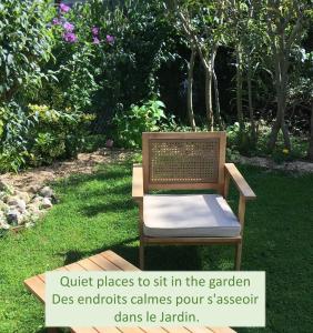 una silla sentada en el césped en un jardín en Farmhouse Gite, en Saint-Georges