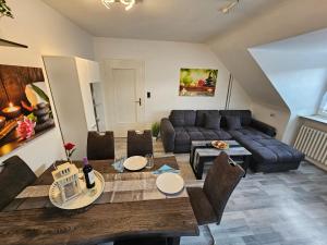 a living room with a couch and a table at Exklusives und helles Dachgeschoss-Apartment No 3 im Zentrum von Kassel, schnelles 1Gbit Internet, Geschirrspüler, Boxspringbetten in Kassel