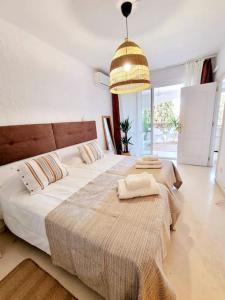 a bedroom with two beds and a pendant light at Apartamento Relax y Golf in Mijas