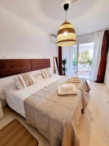 a bedroom with two beds and a chandelier at Apartamento Relax y Golf in Mijas