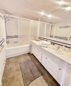 La salle de bains blanche est pourvue d'un lavabo et d'une douche. dans l'établissement Apartamento Relax y Golf, à Mijas
