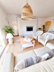 - un salon avec deux canapés blancs et une table dans l'établissement Apartamento Relax y Golf, à Mijas