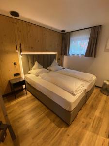 1 dormitorio con 1 cama grande en una habitación en Pra Ciarea Apartments, en Ortisei