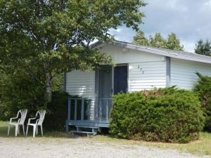 2 Stühle und ein Haus mit einer Veranda in der Unterkunft The Cove Motel & Restaurant in Aulds Cove