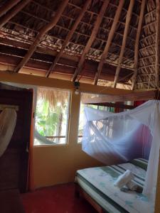 1 dormitorio con 1 cama con mosquitera en Posada Ecohabitas en Mazunte
