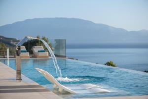 a pool with two white dolphin statues in the water at Sky Birds Villa - Holistic Escape in Skinária