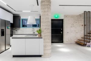 a kitchen with a white counter and a brick wall at Sky Birds Villa - Holistic Escape in Skinária
