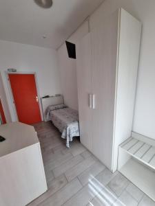 a small white room with a bed and a door at Hotel Mont Blanc in Bellaria-Igea Marina