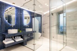 a bathroom with two sinks and a glass shower at Sky Birds Villa - Holistic Escape in Skinária +41 photos