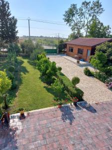 einen Garten mit einem Ziegelweg mit Pflanzen und einem Haus in der Unterkunft Summer Tale Rooms in Lezha