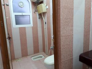 een badkamer met een toilet en een raam bij The calm place in Nizwa in Al Jināh