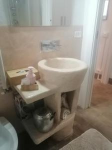 La salle de bains est pourvue d'un lavabo blanc et d'un miroir. dans l'établissement Vecchio Casale Quercetino - Il forno, à Montenero