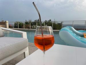 a glass of wine sitting on a table next to a pool at Villa Violaine in Grasse