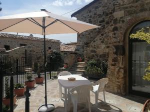 - une table et des chaises avec un parasol sur la terrasse dans l'établissement Vecchio Casale Quercetino - Il forno, à Montenero