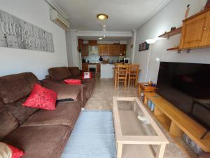 un salon avec un canapé et une télévision dans l'établissement Apartamento Playa Mar 303, à Playas de Orihuela