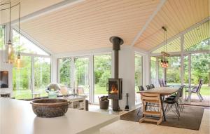 ein offenes Wohnzimmer mit einem Kamin und einem Esstisch in der Unterkunft Gorgeous Home In Dronningmlle With Wifi in Dronningmølle
