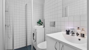a white bathroom with a toilet and a sink at Aker Brygge - Sjøside hjem - Sentral beliggenhet in Oslo +14 photos